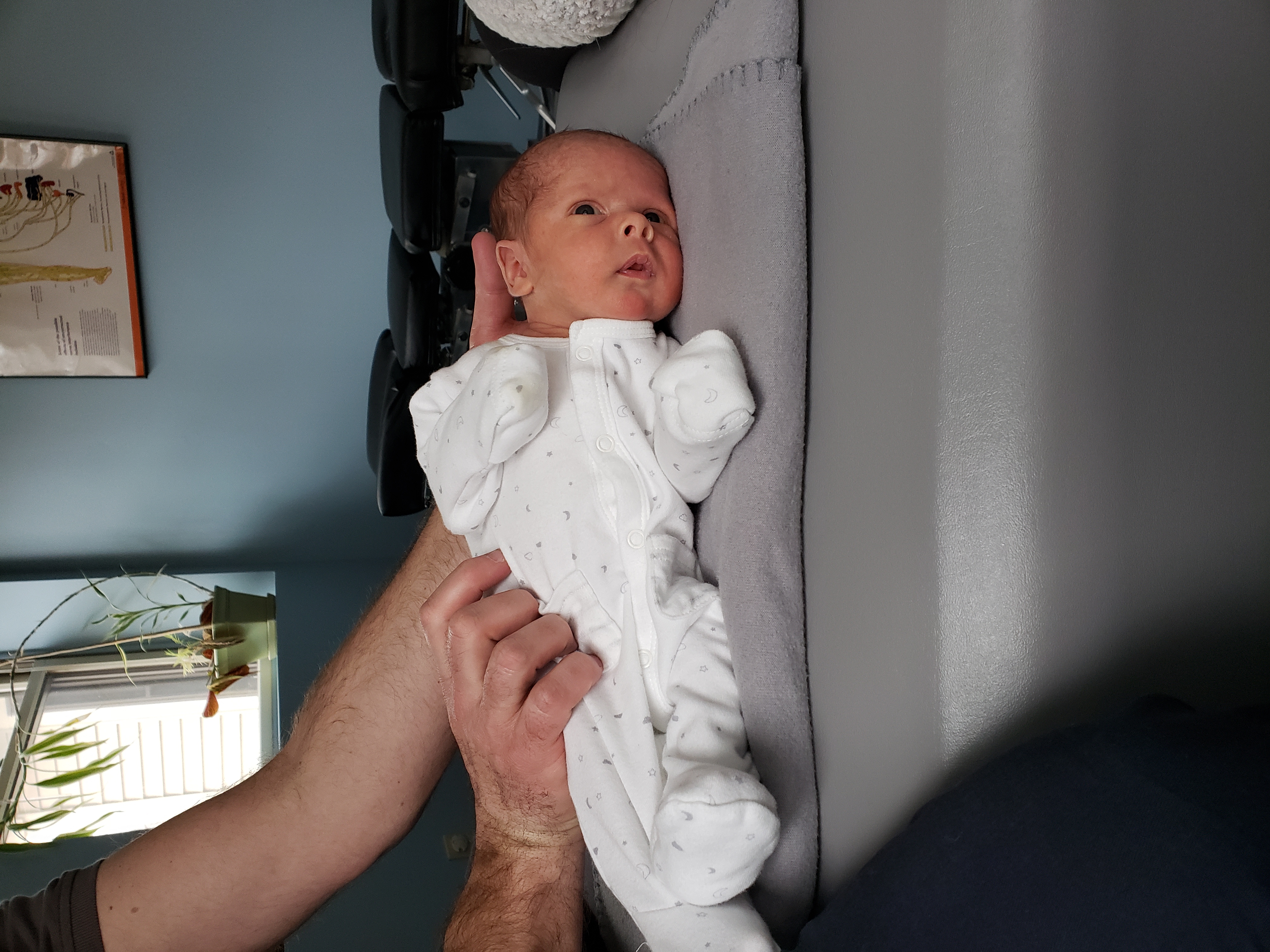 A newborn baby resting on the adjusting table at Community Chiropractic
