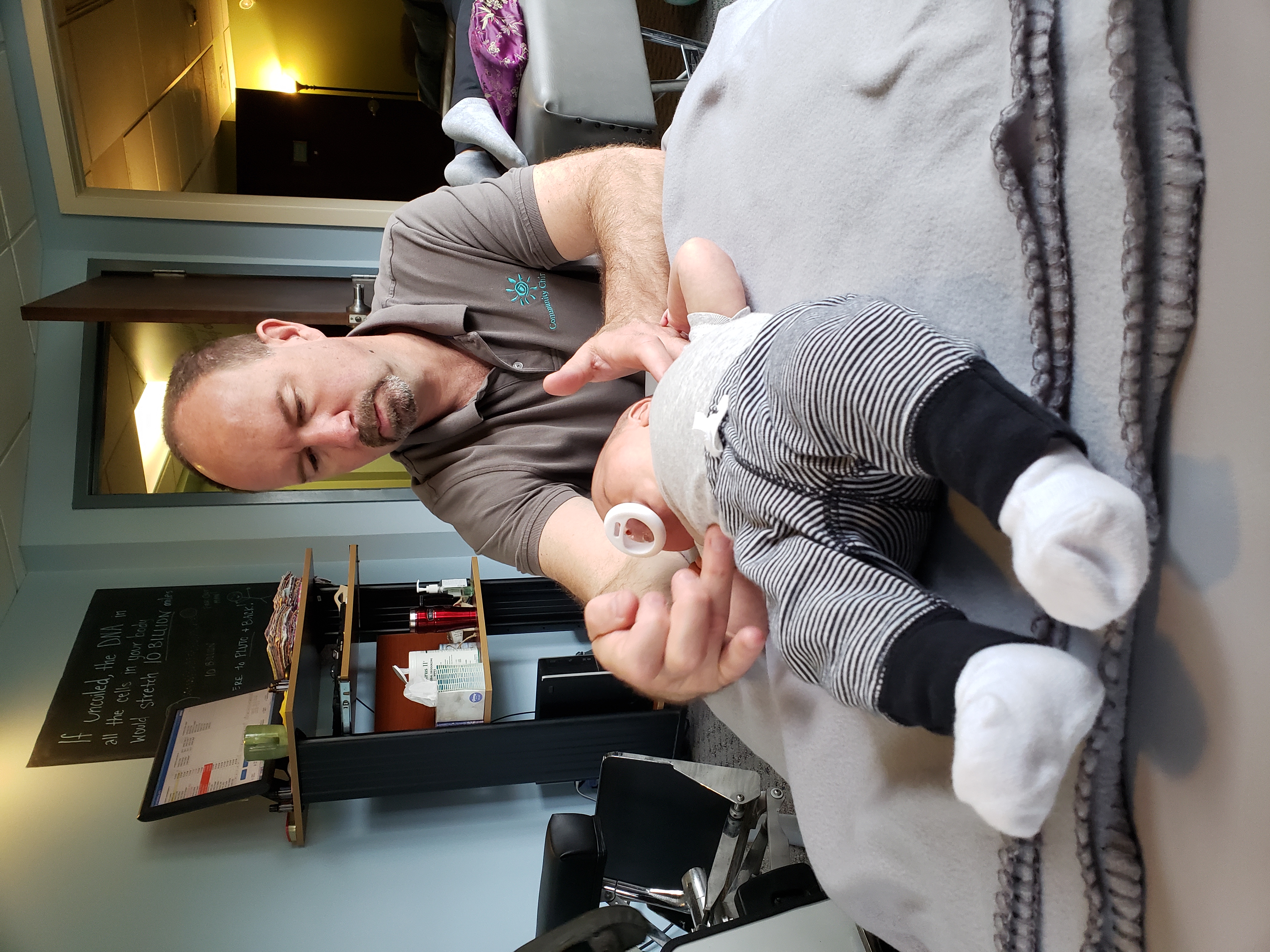 Dr. Steve performing a gentle adjustment on an infant's feet and legs