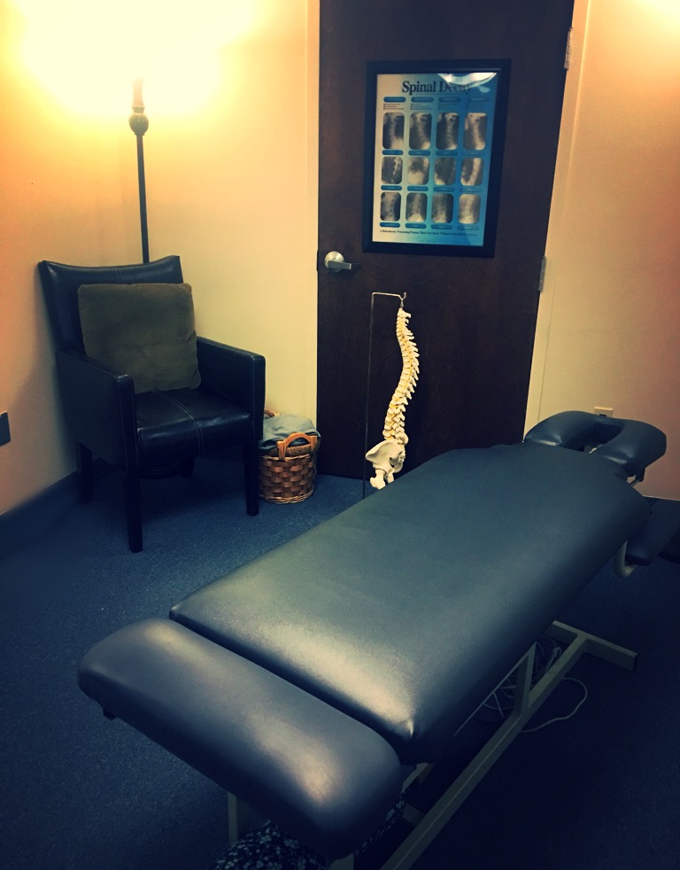 Chiropractic adjusting room featuring a spine anatomy model